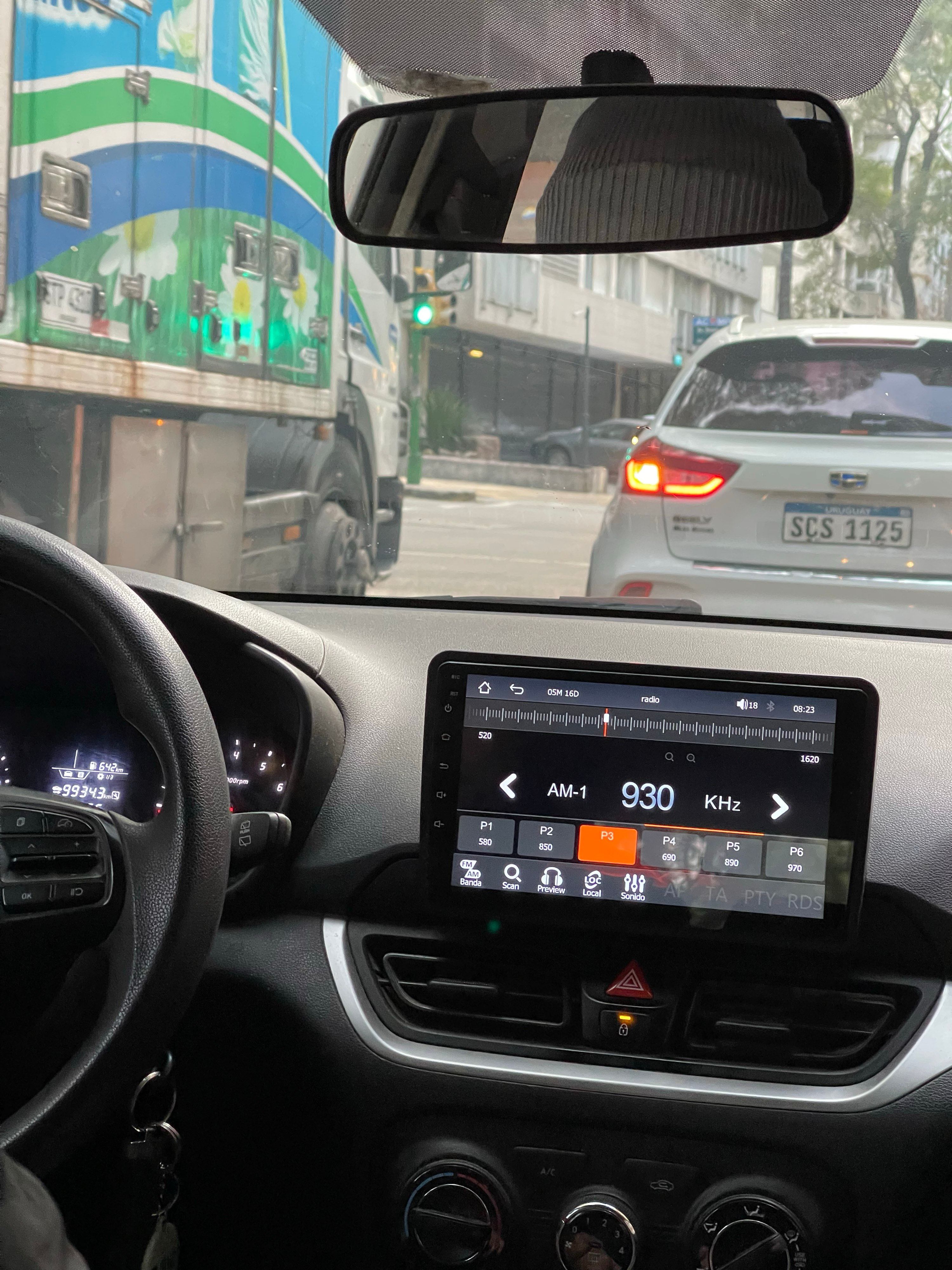 A radio app on a dashboard touchscreen, set to AM 930 KHz.